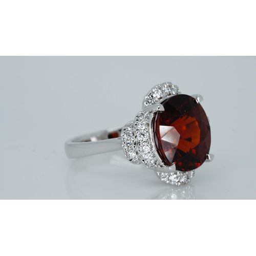 1064 - An 18ct white gold, spessartite garnet and diamond ring, garnet weight 9.03ct, diamond weight 0.47ct... 