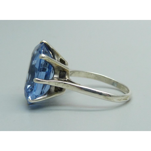 1075 - A ring set with an old cut blue stone, tests as silver, N