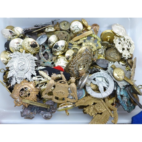 630 - A collection of military cap badges and buttons