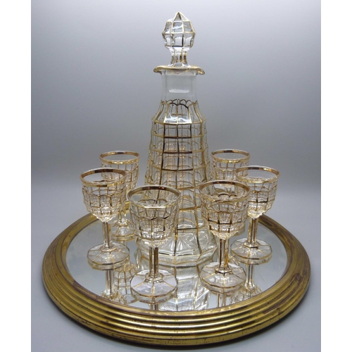 703 - A mid 20th Century gilt drinks set with seven glasses, decanter on a mirrored tray, an Indian pewter... 