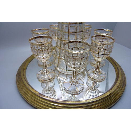 703 - A mid 20th Century gilt drinks set with seven glasses, decanter on a mirrored tray, an Indian pewter... 