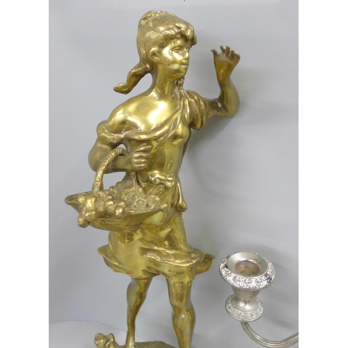 816 - A brass figure of a girl holding a basket, 44.5cm and a candelabra