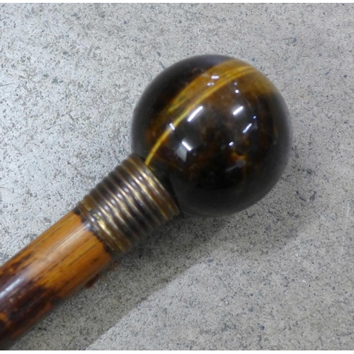 836 - A walking cane with globular tigers eye top