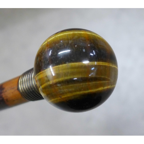 836 - A walking cane with globular tigers eye top