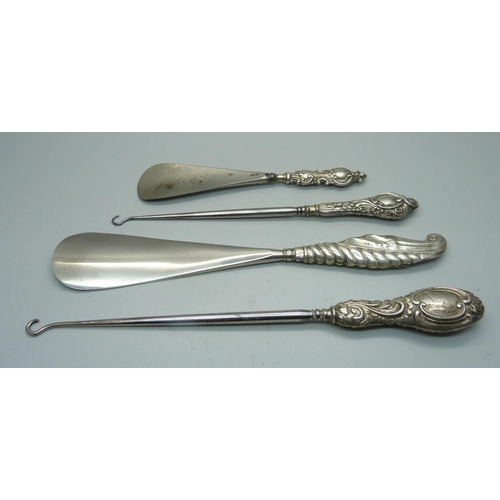 940 - Four silver handled tools; two button hooks and two shoe horns