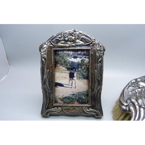 946 - A silver backed Art Nouveau brush, Birmingham 1911, and a silver photograph frame, Birmingham 1910