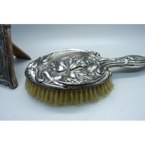 946 - A silver backed Art Nouveau brush, Birmingham 1911, and a silver photograph frame, Birmingham 1910