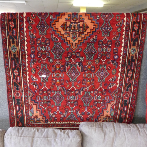 1493 - A rich red ground Persian Nahavan village rug, full pile with Kork wool, 245cm x 186cm