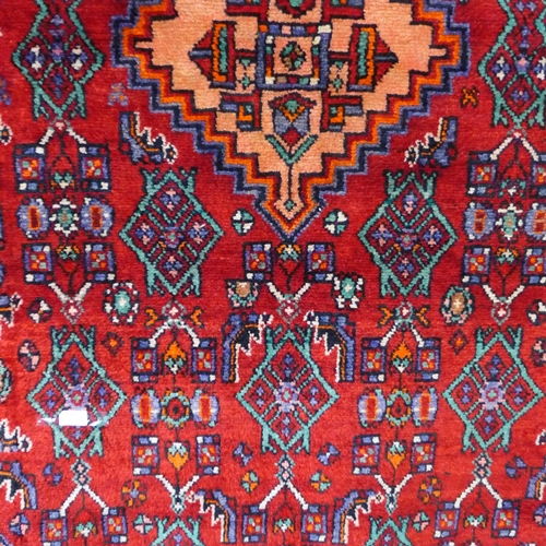 1493 - A rich red ground Persian Nahavan village rug, full pile with Kork wool, 245cm x 186cm