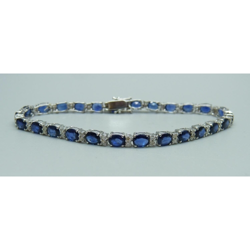 1084 - A white metal, diamond and sapphire tennis bracelet, 8g