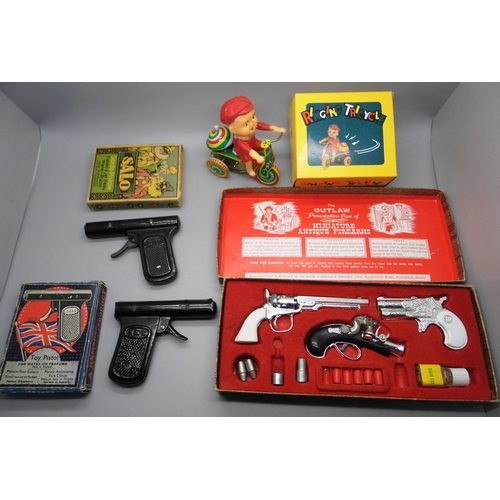 668 - An Outlaw Miniature Firearms gun set, two vintage metal water pistols (tested, not working) and a Ch... 