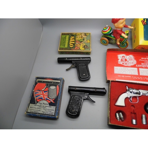 668 - An Outlaw Miniature Firearms gun set, two vintage metal water pistols (tested, not working) and a Ch... 