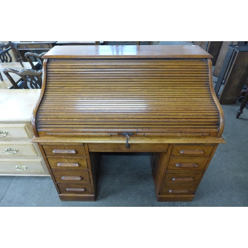 125 - An early 20th Century oak tambour roll top desk