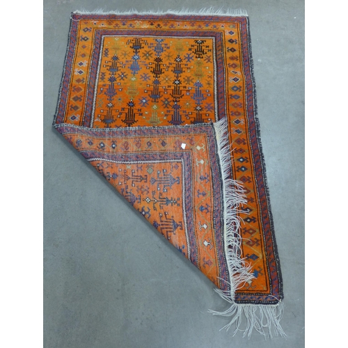 250 - An eastern hand knotted orange ground rug