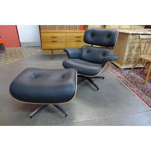 36W - A Charles & Ray Eames style simulated rosewood and black leather revolving lounge chair and ottoman