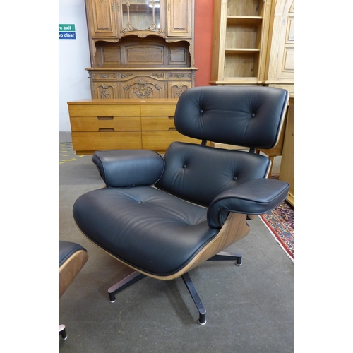 36W - A Charles & Ray Eames style simulated rosewood and black leather revolving lounge chair and ottoman