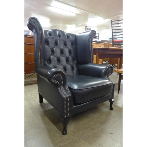 4 - A black leather Chesterfield wingback armchair