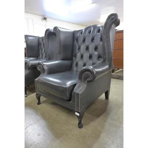 4 - A black leather Chesterfield wingback armchair