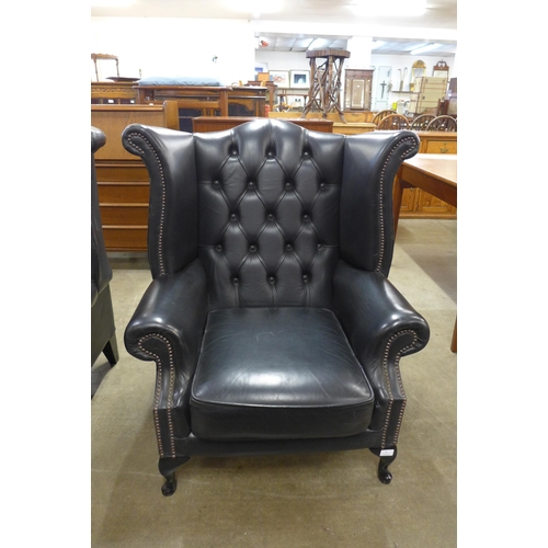 4 - A black leather Chesterfield wingback armchair