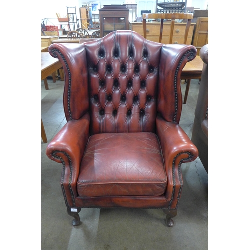 94 - An oxblood red leather Chesterfield wingback armchair