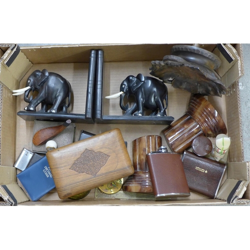 1154 - A box containing two pairs of book ends, onyx and ebony elephants, lighters, paperweights, two hip f... 