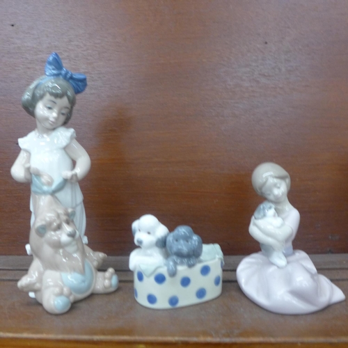 609 - Three Nao figures; girl with soft toy, girl with puppy and two dogs in a basket, all boxed