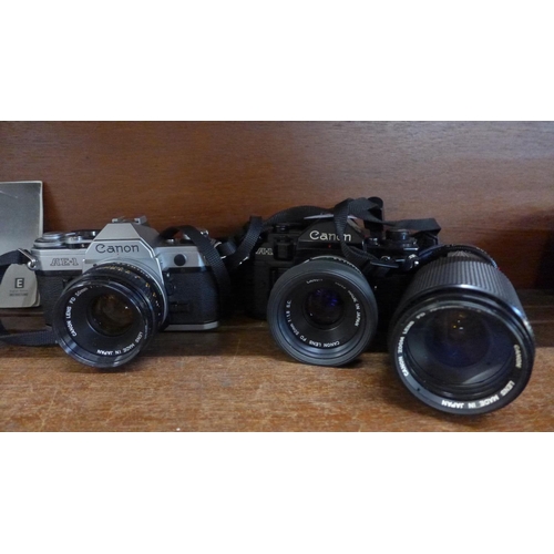 646 - Two Canon 35mm film cameras, A-1 black body and AE-1 silver/black body, both with 50mm lenses and a ... 