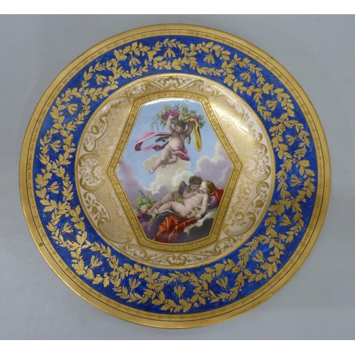 723 - A Sevres plate with bleu lapis and gilt border with the central reserve decorated with cherubs and g... 