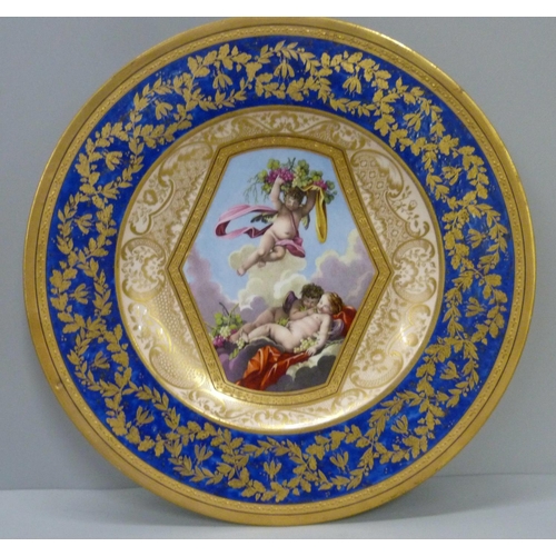 723 - A Sevres plate with bleu lapis and gilt border with the central reserve decorated with cherubs and g... 