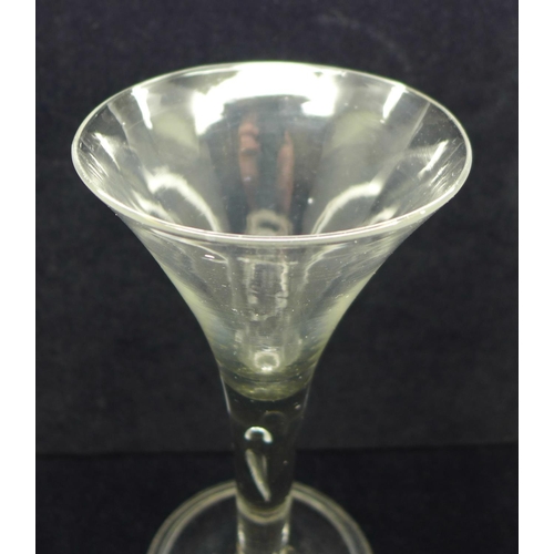 728 - An 18th Century tall wine glass, circa 1740, having a drawn trumpet bowl over a teared stem on a wid... 