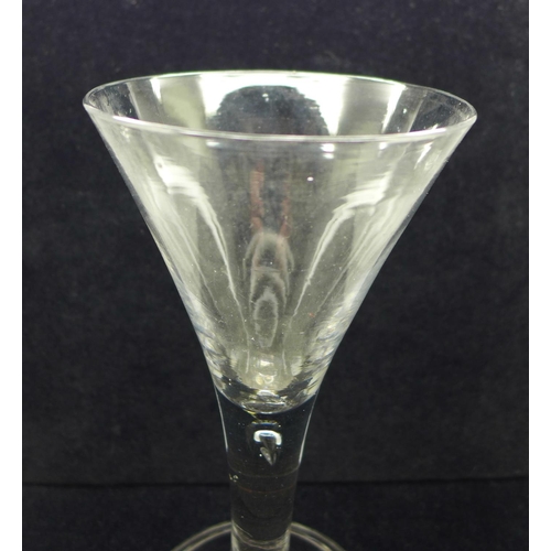 729 - An 18th Century heavy wine glass, circa 1740, with drawn trumpet bowl over a teared stem on a wide f... 