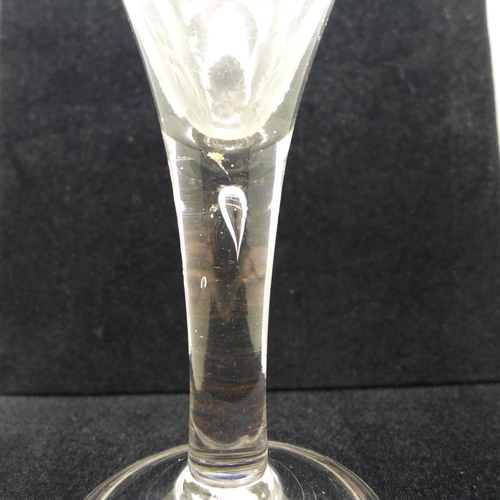 729 - An 18th Century heavy wine glass, circa 1740, with drawn trumpet bowl over a teared stem on a wide f... 