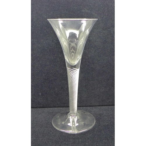 746 - An 18th Century wine glass with trumpet bowl over an air twist stem on a wide conical foot, 18cm