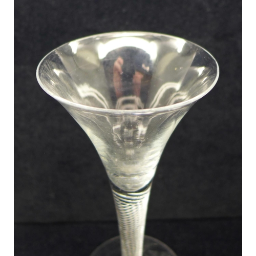 746 - An 18th Century wine glass with trumpet bowl over an air twist stem on a wide conical foot, 18cm