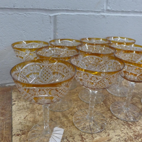 760 - A set of eleven champagne coupes each with engraved amber coloured bowl over a hexagonal faceted ste... 