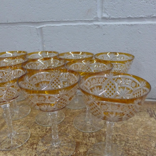 760 - A set of eleven champagne coupes each with engraved amber coloured bowl over a hexagonal faceted ste... 