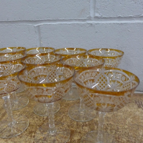 760 - A set of eleven champagne coupes each with engraved amber coloured bowl over a hexagonal faceted ste... 