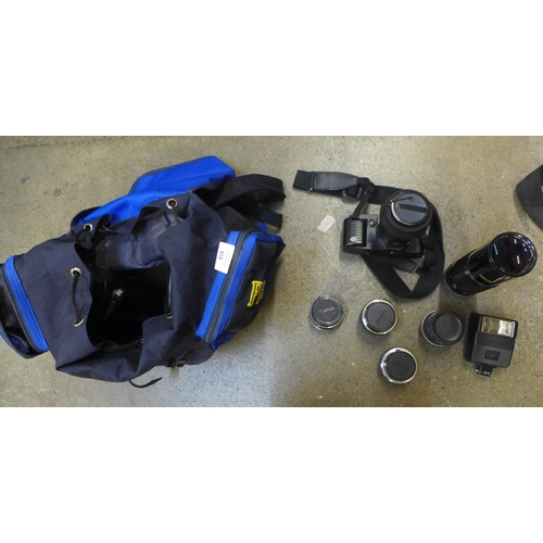 818 - A Canon T70 35mm fim camera, two spare Canon lenses, 24mm and 300mm, an adaptor, Vivitor multiplier ... 