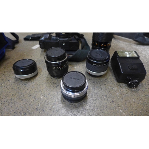 818 - A Canon T70 35mm fim camera, two spare Canon lenses, 24mm and 300mm, an adaptor, Vivitor multiplier ... 