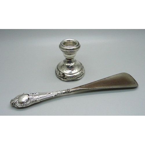 895B - A small silver candlestick, a/f, and a silver handled shoehorn, a/f