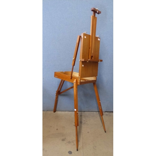 406 - A teak artist's fitted travelling easel, with paints