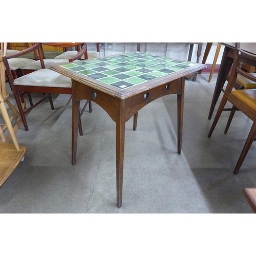 151 - An Arts and Crafts oak and green tiled top occasional table