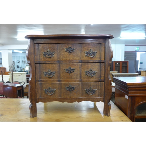 195 - A French oak bombe shaped petit commode