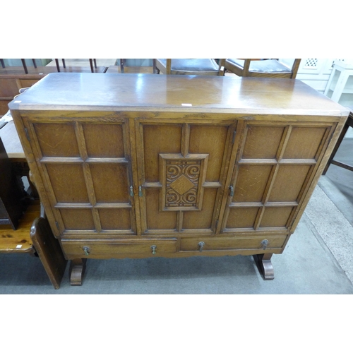 275 - An Art Deco carved oak three door nursery cupboard