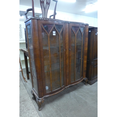 277 - A walnut serpentine two door display cabinet