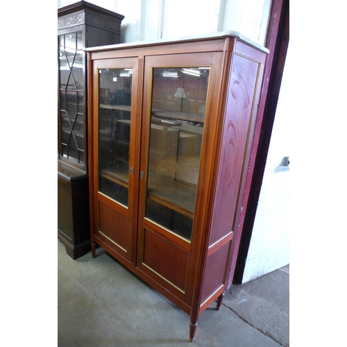 293 - A French Empire style mahogany and marble topped two door bookcase