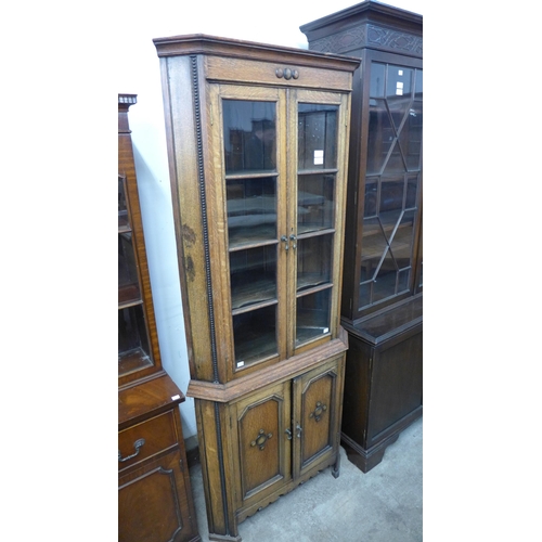 295 - An early 20th Century oak freestanding splay front corner cabinet