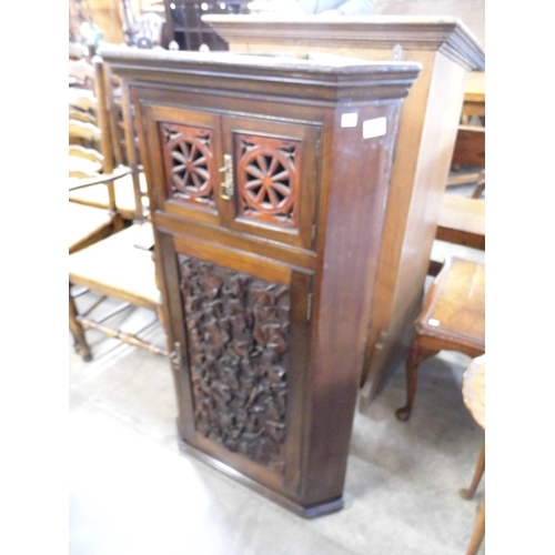 313 - A Victorian Aesthetic Movement carved walnut splay front wall hanging corner cupboard