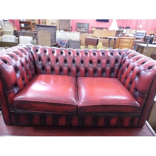 337 - An oxblood red leather Chesterfield settee