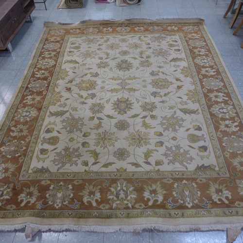 356 - A large eastern beige ground rug